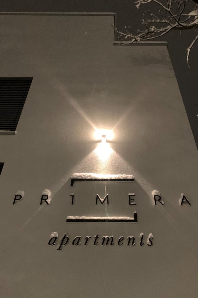 Fassade mit dem Logo der Primara Apartments im Winter.