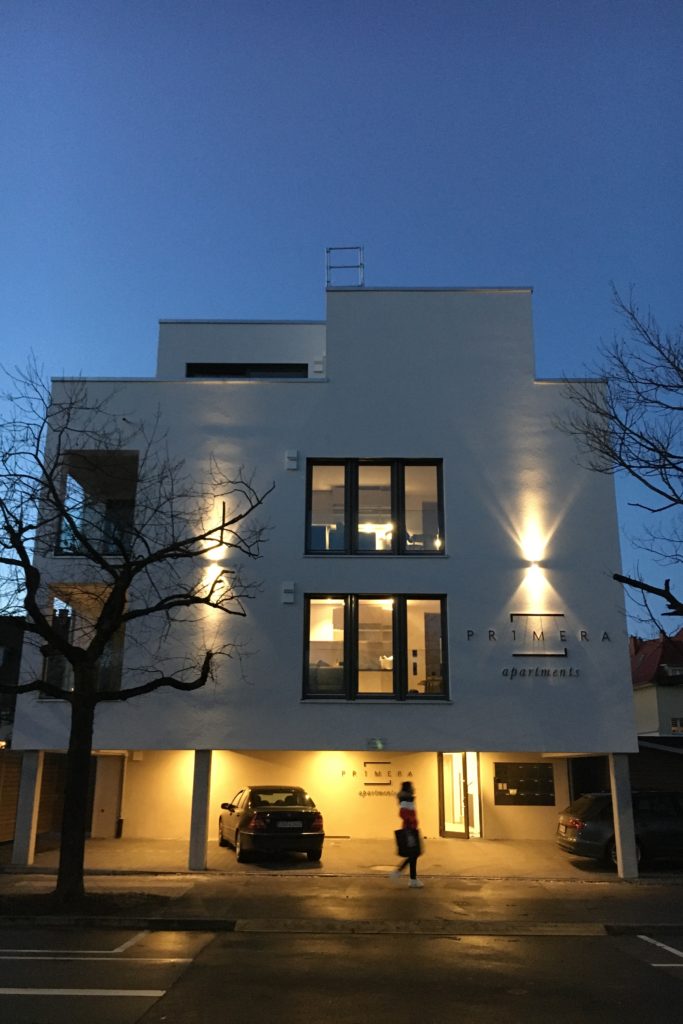Aussenanischt Primera Apartments mit Parkplätzen.
